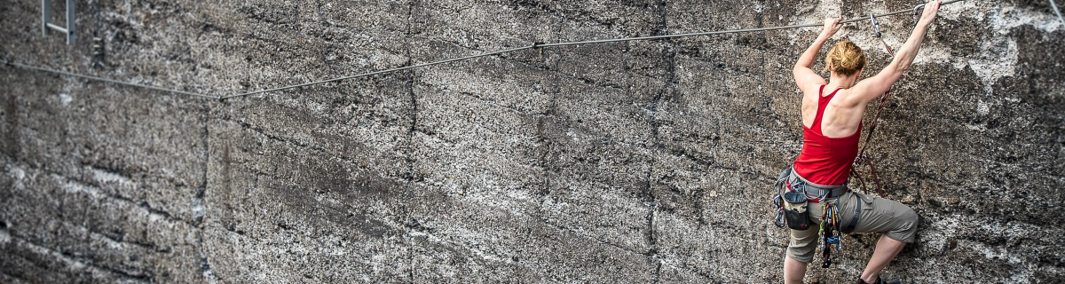 Rock climber scaling cliff face