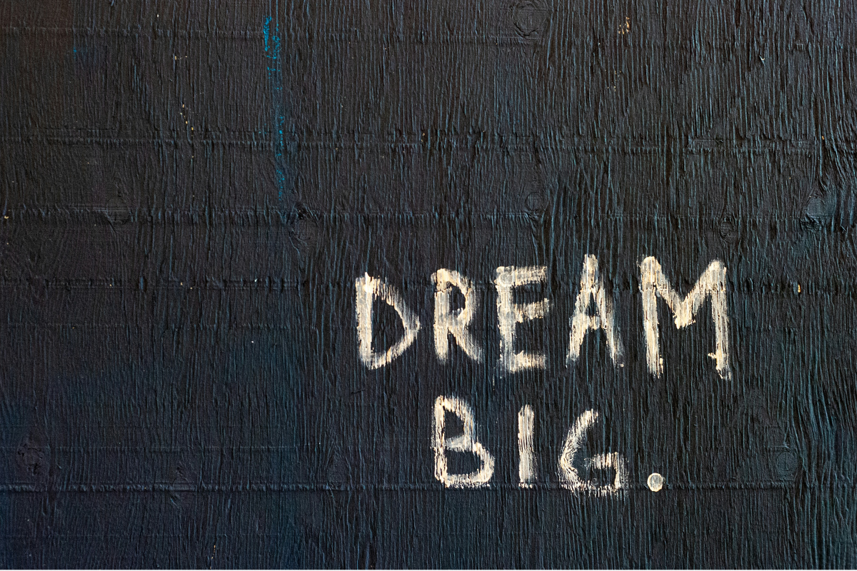 Black wall with white writing which reads 'Dream Big'.